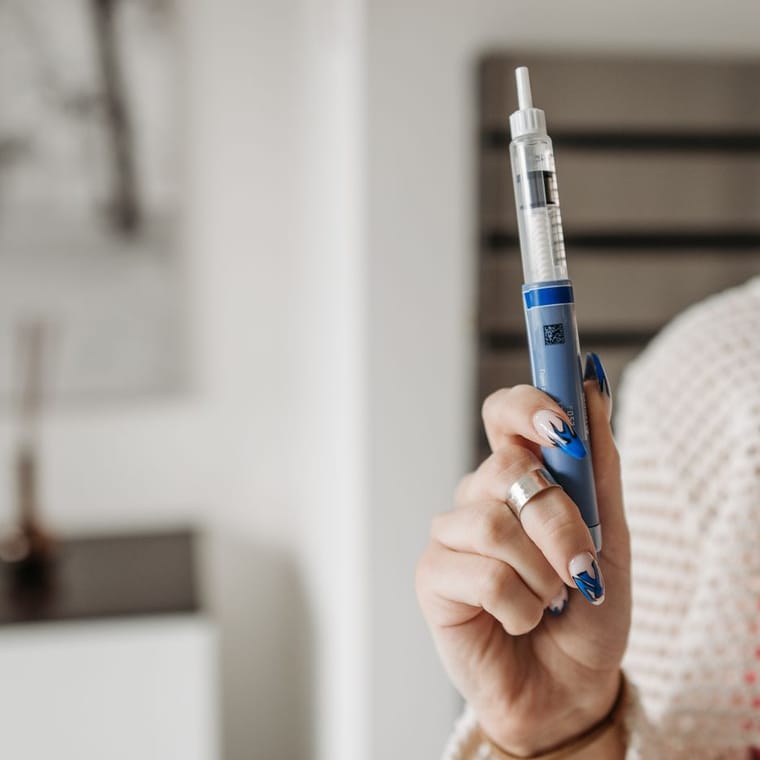 A hand holding a GLP-1 injection pen